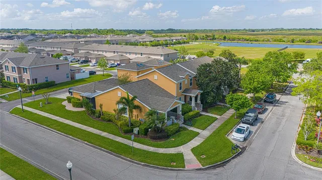 an aerial view of a house with a garden and lake view