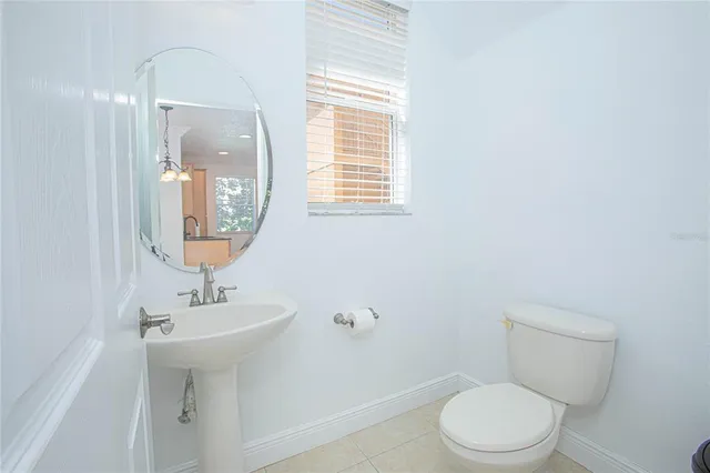 a bathroom with a toilet a sink a mirror and vanity