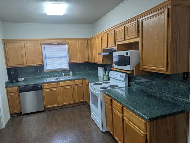 a kitchen with stainless steel appliances granite countertop a sink stove and cabinets