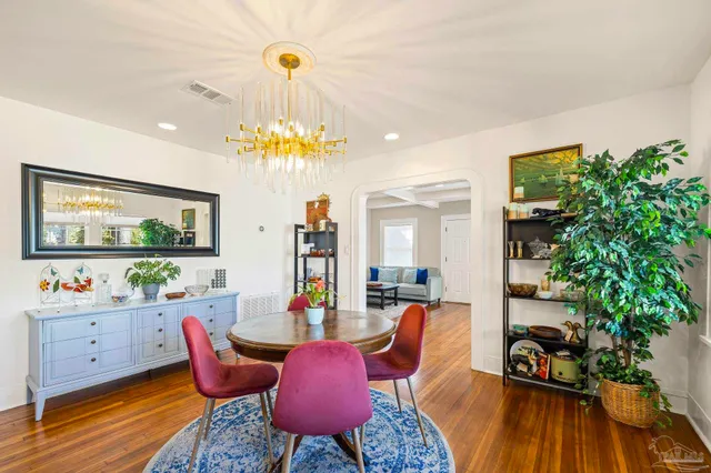 a view of a dining room with furniture a chandelier and wooden floor