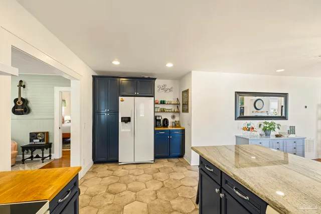a living room with stainless steel appliances kitchen island granite countertop furniture and a refrigerator