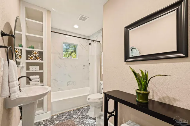 a bathroom with a granite countertop sink a toilet and a bathtub