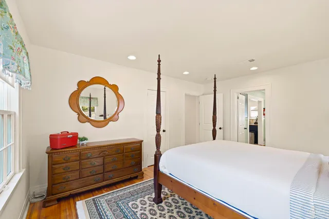 a bed room with a bed a mirror and lamp