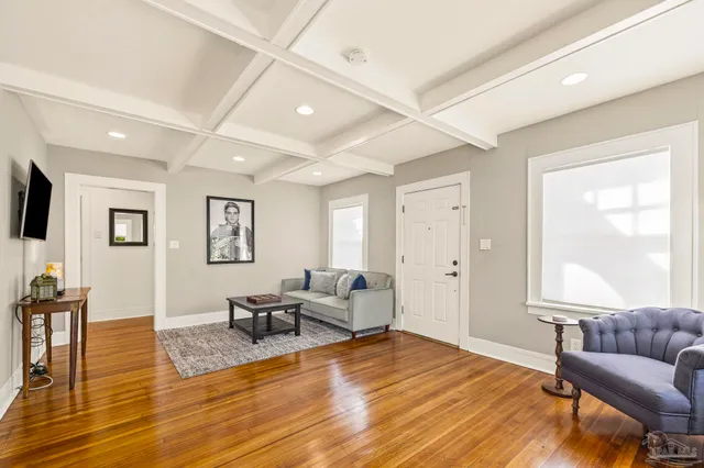 a living room with furniture and a wooden floor