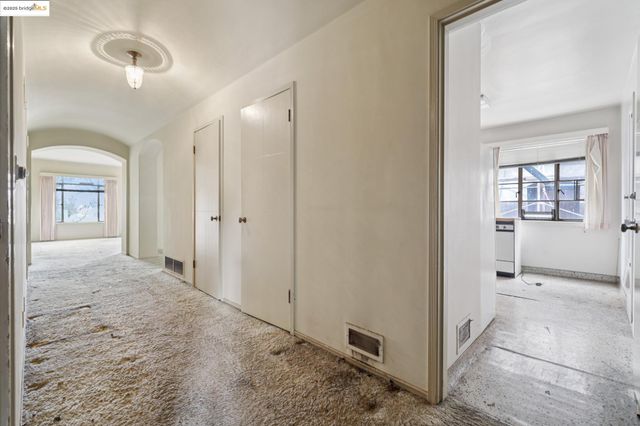 an empty room with fireplace and windows