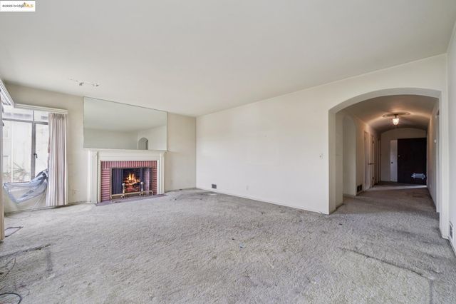 an empty room with fireplace and windows