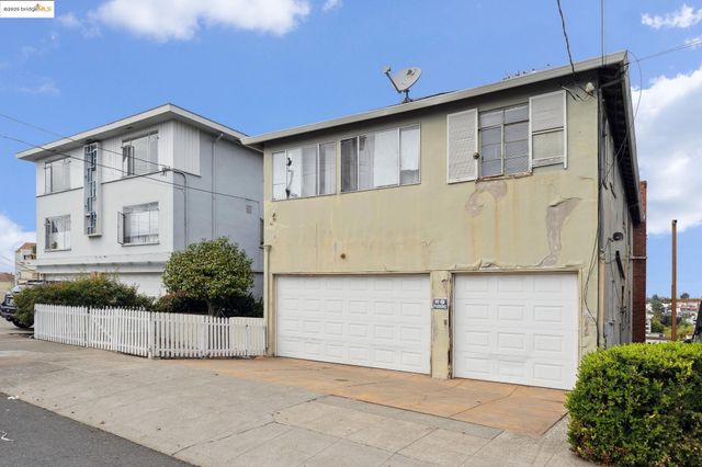 a front view of a house with white fence