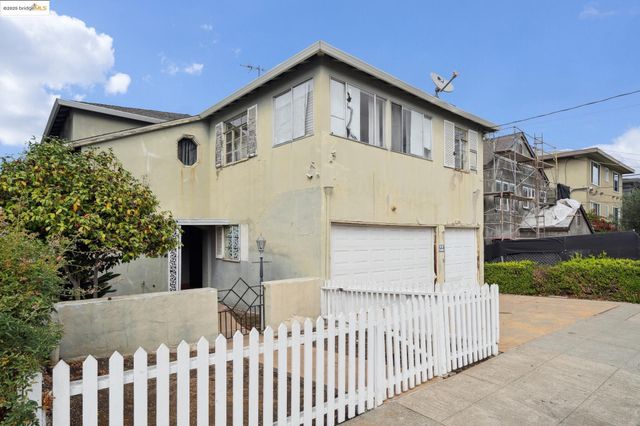 a view of a house with a small yard and wooden fence