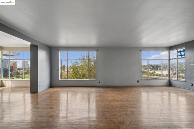 a view of an empty room with a window and a fireplace