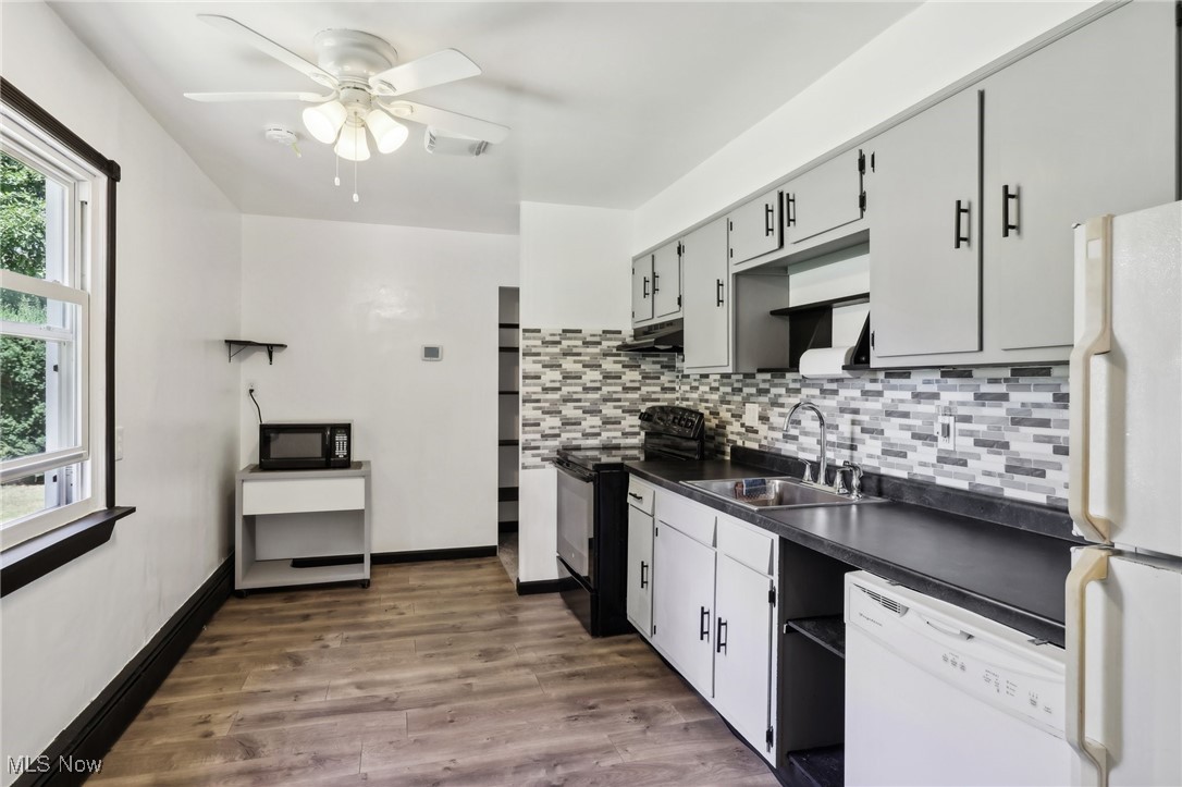 1829 Clyde Road Madison, OH 44057 - Photo 17 of 40 Kitchen with black appliances, sink, ceiling fan, decorative backsplash, and dark wood-type flooring