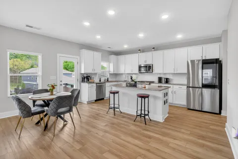 a kitchen with a table chairs refrigerator microwave and cabinets