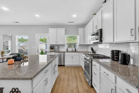 a kitchen with stainless steel appliances granite countertop sink stove and cabinets