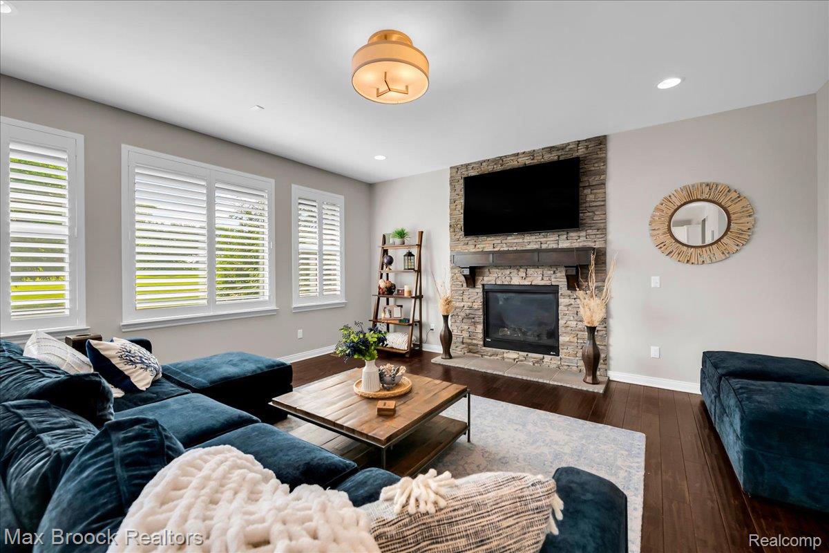 1126 Queensboro Drive Rochester, MI 48307 - Photo 11 of 66 Living area featuring a stone accent wall, fireplace with mantel, and wood-finish flooring