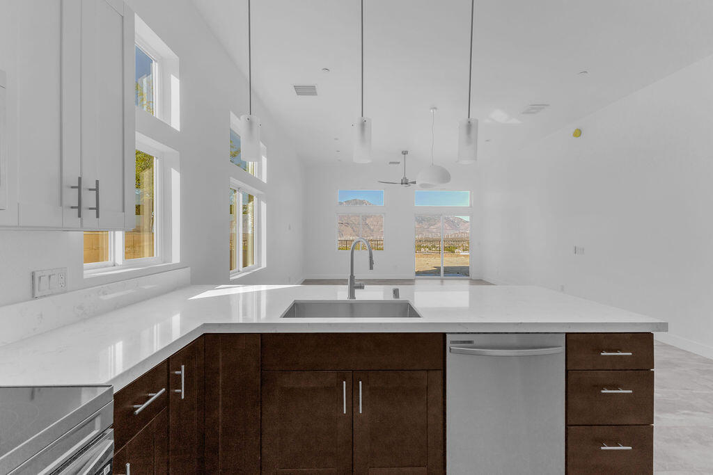66751 San Felipe Road Desert Hot Springs, CA 92240 - Photo 12 of 59 a kitchen with kitchen island granite countertop a sink cabinets and stainless steel appliances