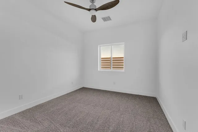 a view of an empty room with a ceiling fan