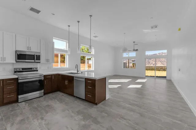 a view of a kitchen with stainless steel appliances cabinets and a window