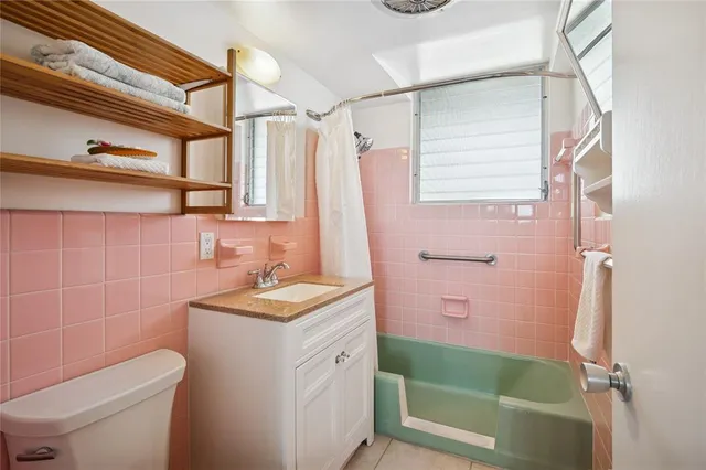 a bathroom with a granite countertop sink a toilet and shower