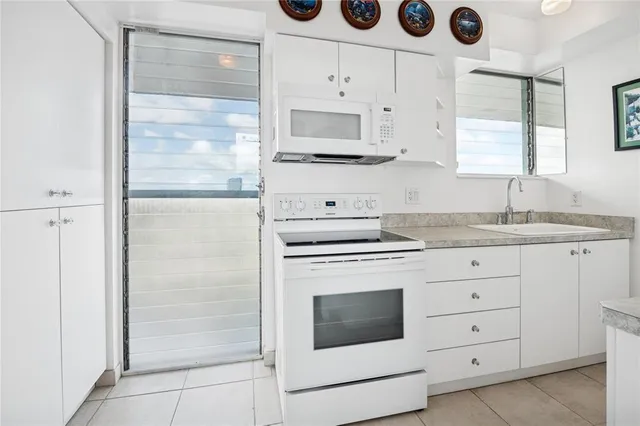 a kitchen with cabinets appliances and a window