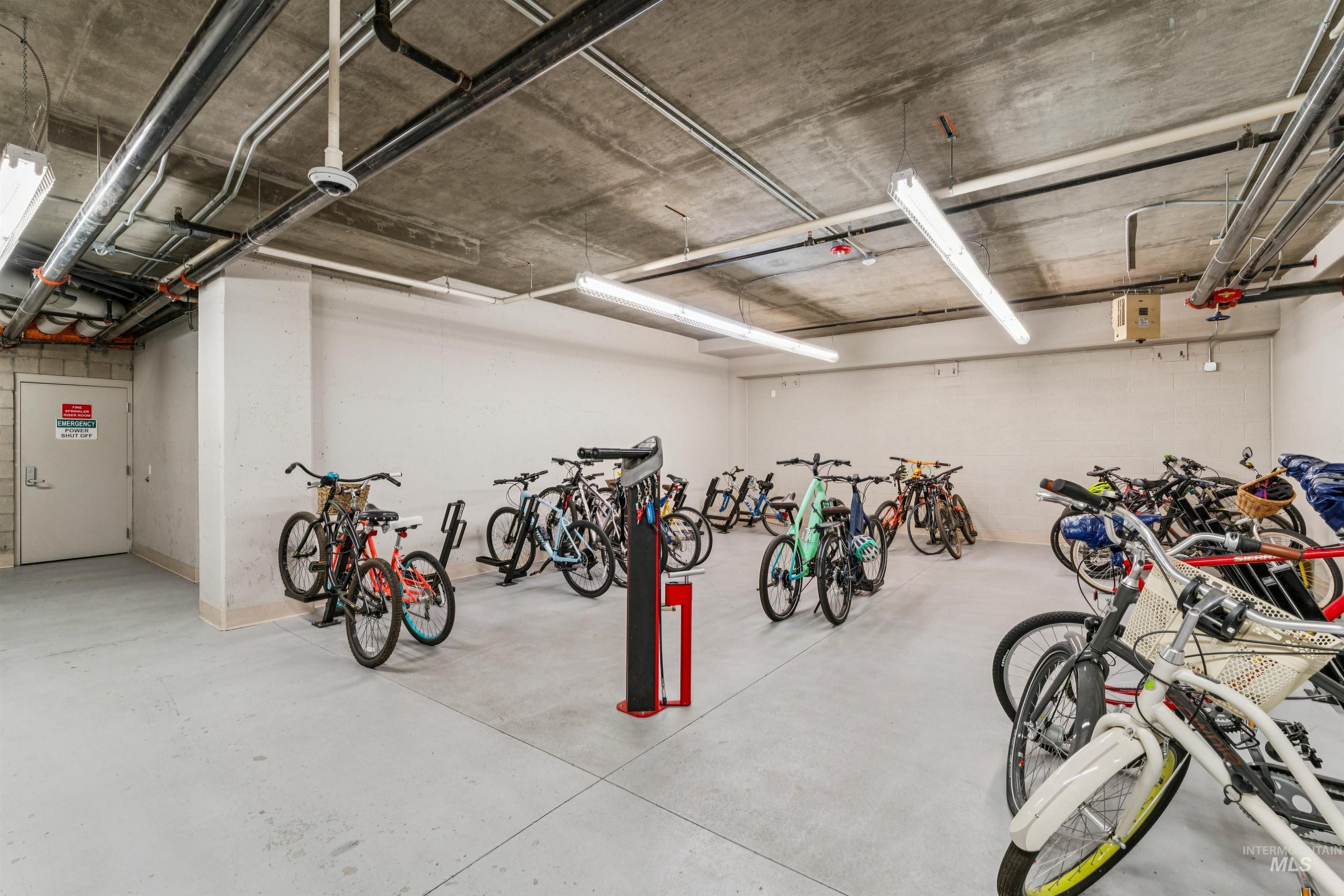 119 South 10th Street, Unit 307 Boise, ID 83702 - Photo 40 of 47 Dedicated bicycle storage area featuring multiple bike racks, a concrete ceiling with exposed conduits, and overhead fluorescent lighting