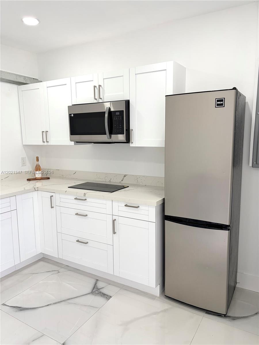 13065 Southwest 263rd Terrace, Unit 2 Homestead, FL 33032 - Photo 2 of 15 a kitchen with a refrigerator sink and microwave