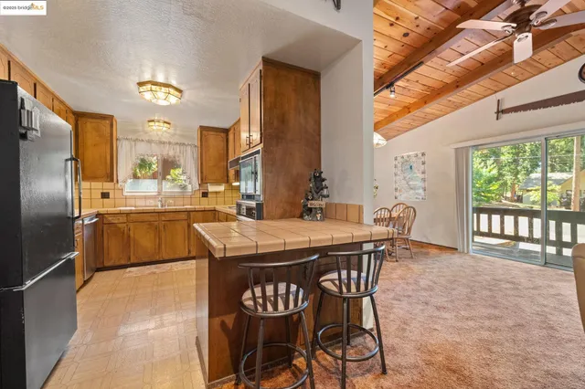 a kitchen with granite countertop a dining table chairs and a refrigerator
