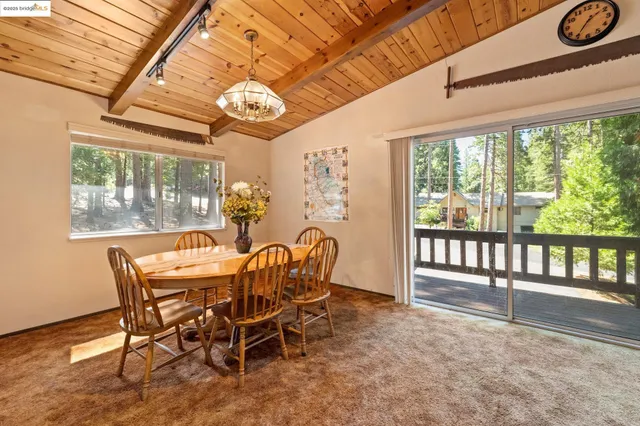 a dining room with furniture a chandelier and wooden floor