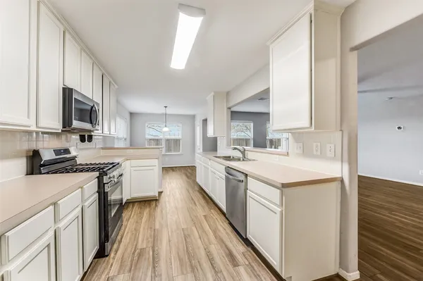 a large kitchen with a sink and cabinets