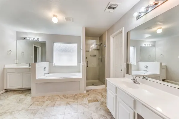 a spacious bathroom with a bathtub sink and mirror