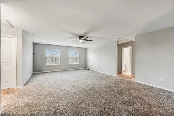 a view of a big room with windows and chandelier fan