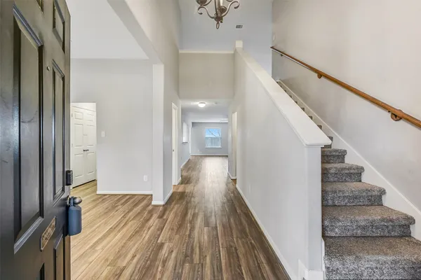 a view of a hallway with wooden floor and staircase