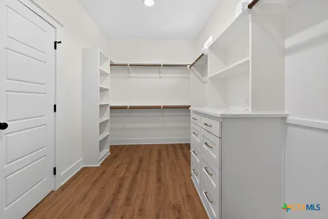 an empty room with wooden floor ceiling fan and windows