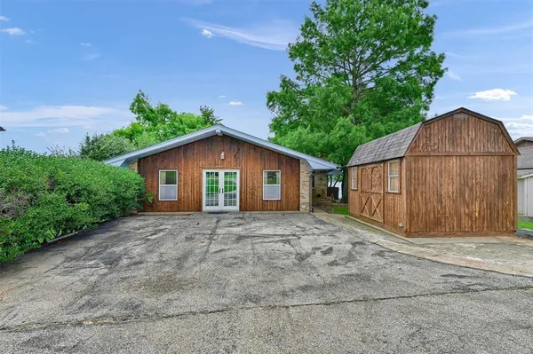 a view of backyard of house with wooden fence