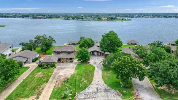 an aerial view of a house with a garden and lake view