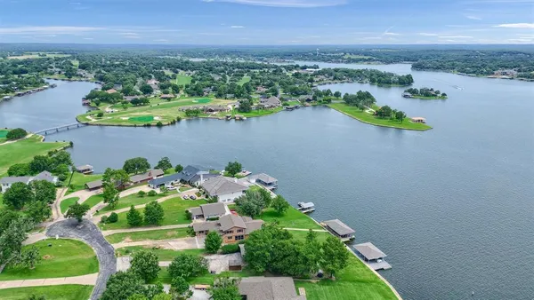 an aerial view of a house with a yard and lake view
