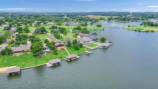 an aerial view of a house with a garden and lake view
