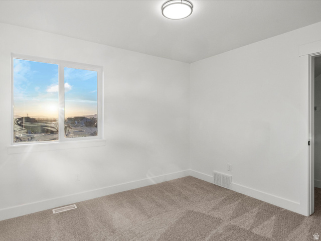 1267 West 2350 South Perry, UT 84302 - Photo 30 of 35 Bright room featuring a picture window with a scenic backdrop, neutral carpet flooring, white baseboards, and a flush-mount ceiling light