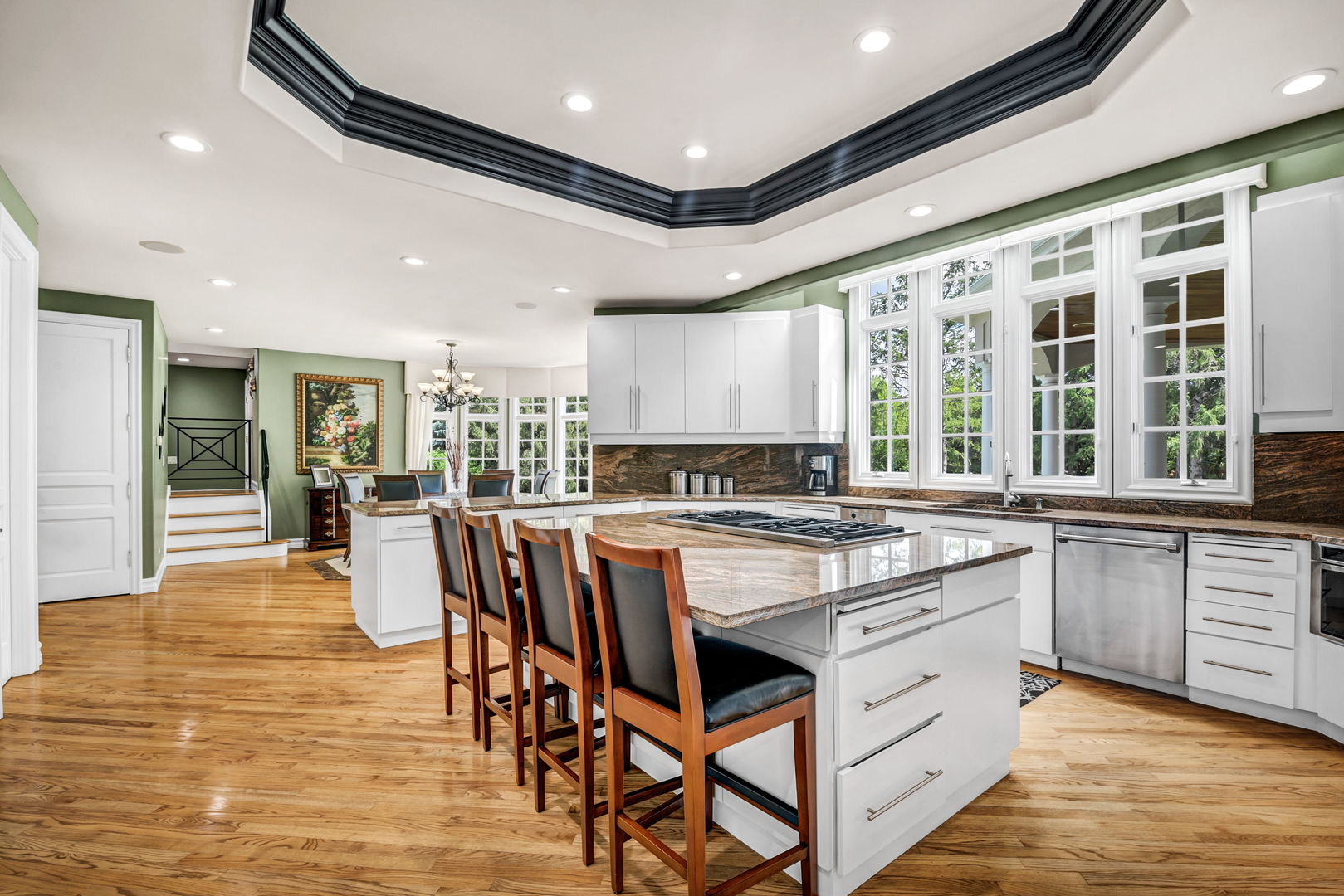 210 Indian Trail Road Oak Brook, IL 60523 - Photo 13 of 48 a open kitchen with stainless steel appliances granite countertop a stove top oven a sink dishwasher a dining table and chairs with wooden floor