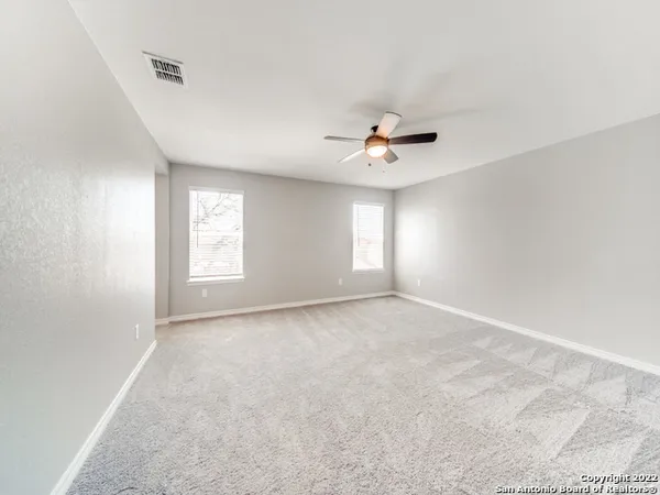 a view of an empty room with a ceiling fan
