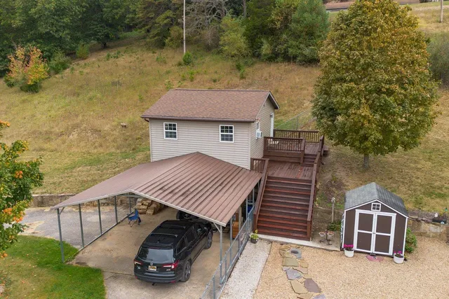 an aerial view of residential house with outdoor space and trees all around