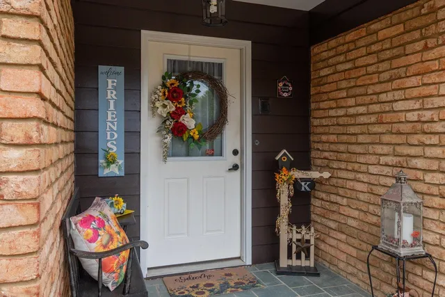 front view of house with a bench and potted plants