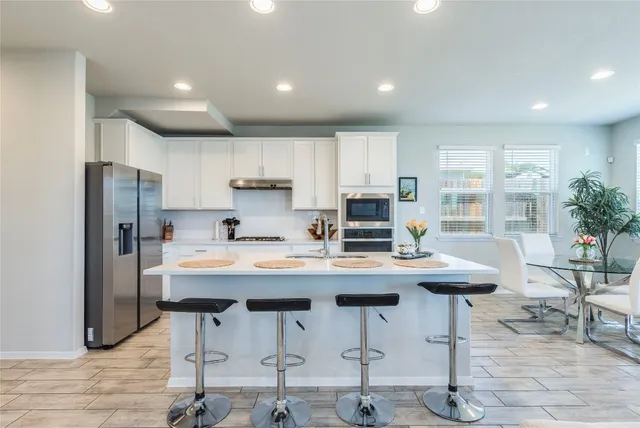 a kitchen with stainless steel appliances kitchen island furniture and wooden cabinets