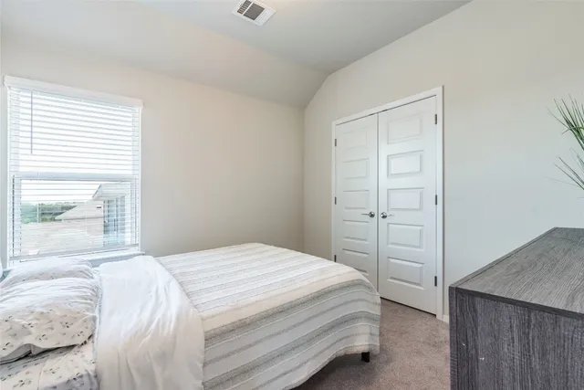 a bedroom with a bed and painting on the wall