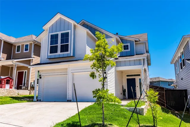 a front view of a house with a yard and a garage