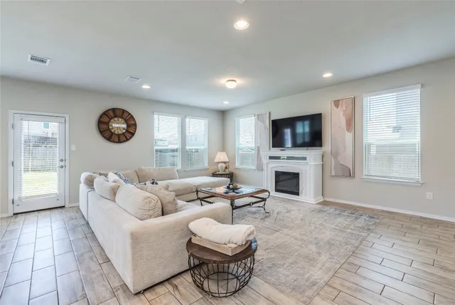 a living room with furniture a fireplace and a flat screen tv