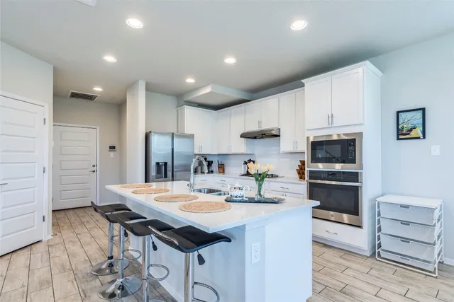 a kitchen with stainless steel appliances kitchen island granite countertop a sink and cabinets