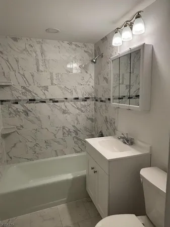a bathroom with a sink toilet vanity and shower