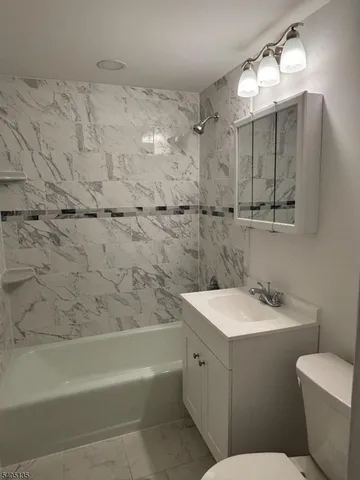 a bathroom with a sink toilet vanity and shower