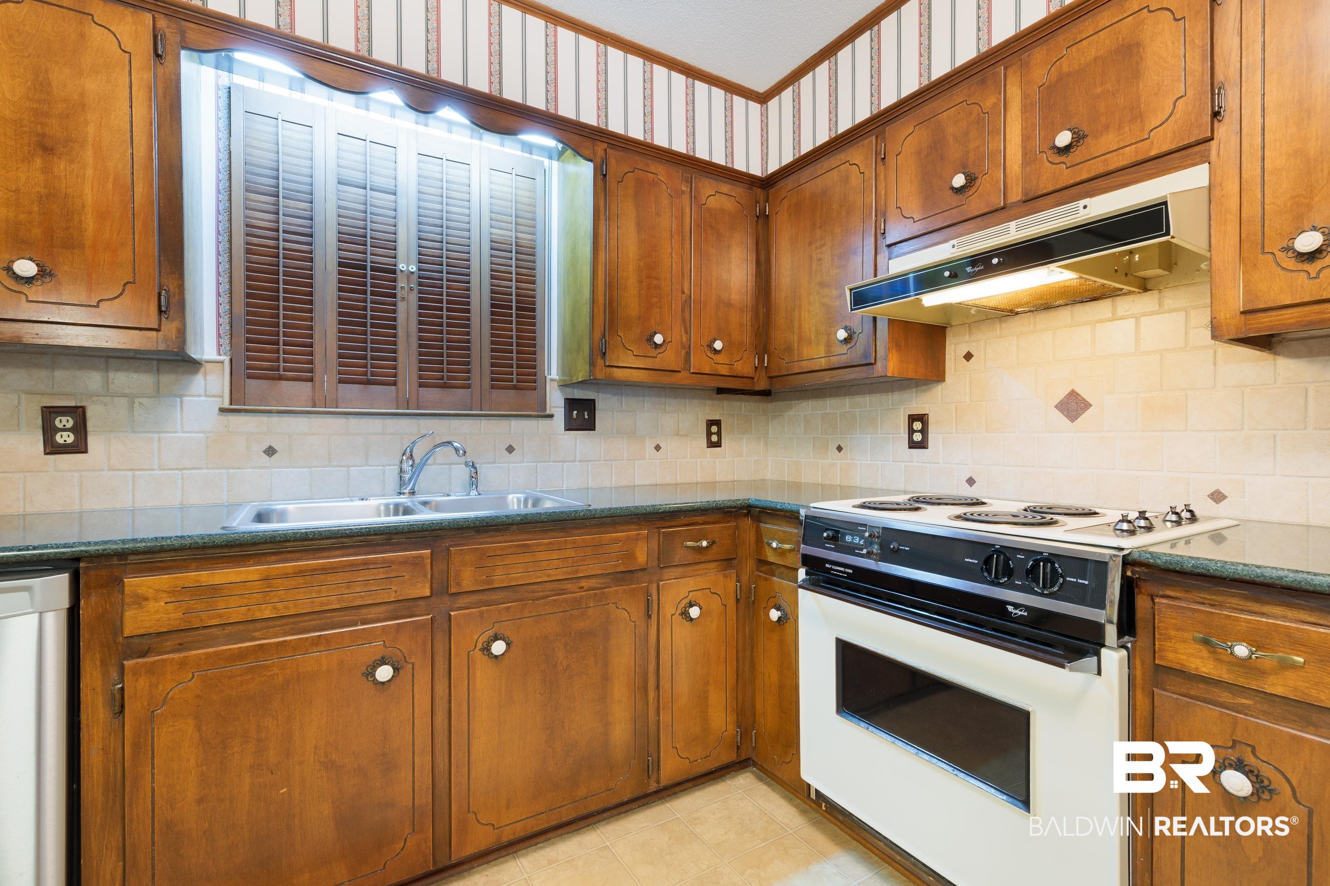 1367 Spring Valley Court Mobile, AL 36693 - Photo 8 of 29 Kitchen featuring extensive wood cabinetry, a double basin stainless steel sink, a built-in electric range with integrated oven, a tiled backsplash with diamond accents, and laminate countertops