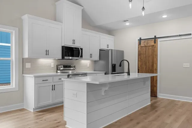 a kitchen with appliances a sink and a microwave