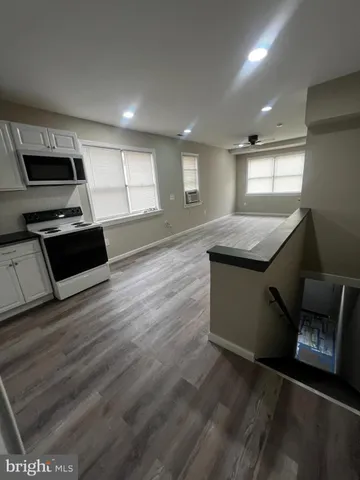 a kitchen with stainless steel appliances refrigerator wooden floor sink and stove